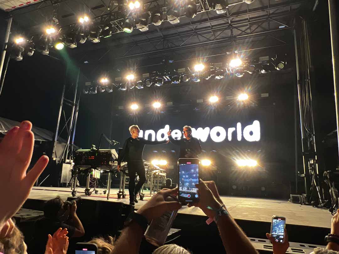 The members of the the band Underworld celebrating on stage after a performance in Miami